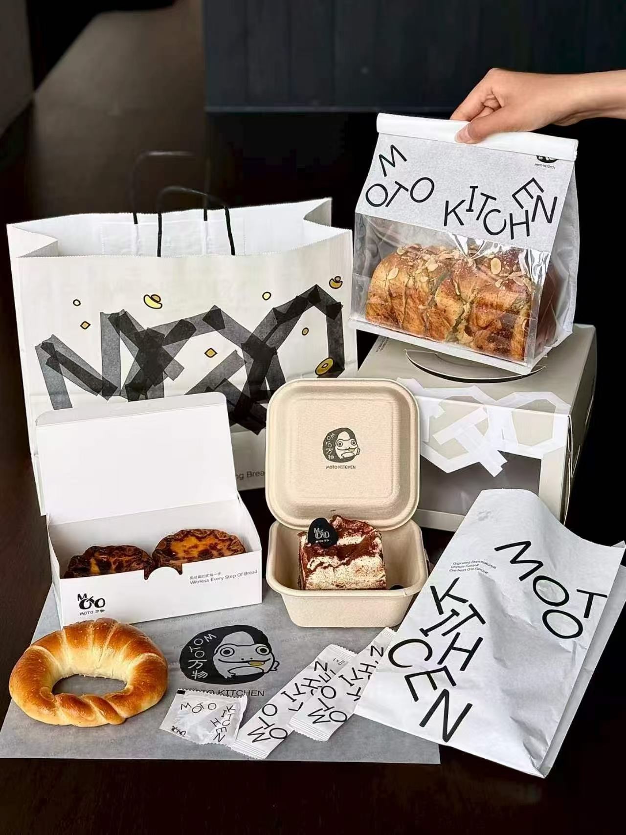 Reference photo showing a coordinated black and white bakery packaging set.