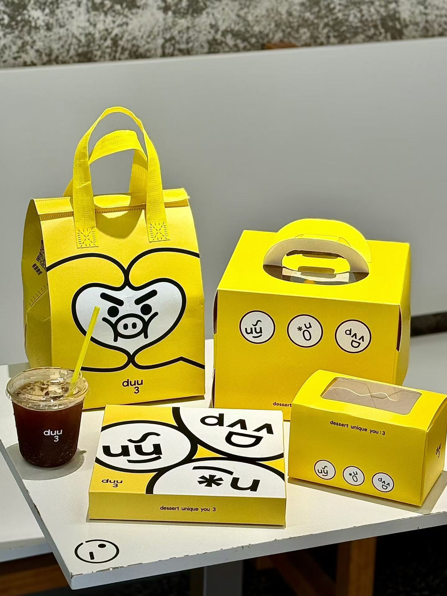 Reference photo showing a bright yellow cafe takeaway packaging set.