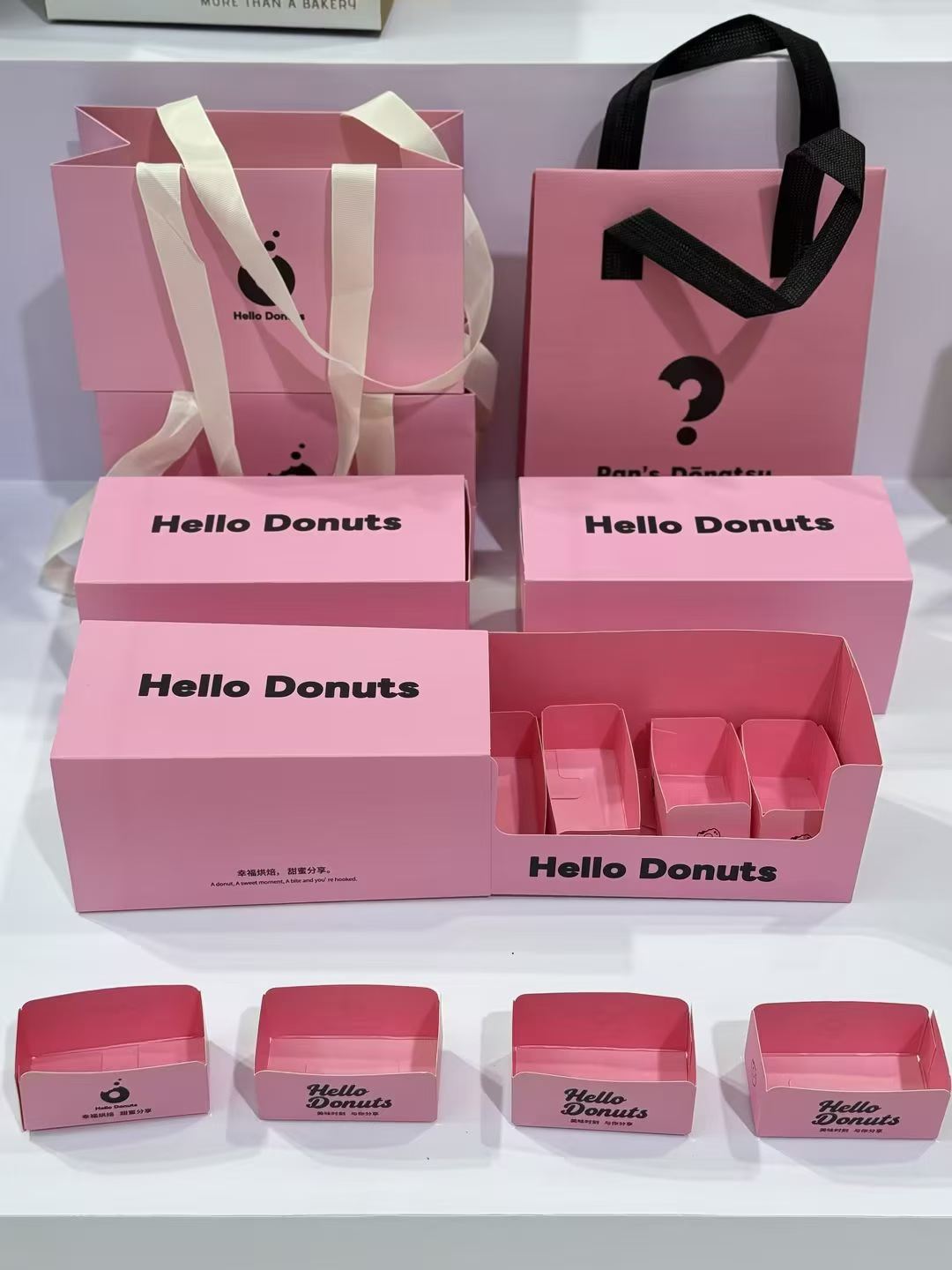 Reference photo showing coordinated pink donut boxes and paper bags.