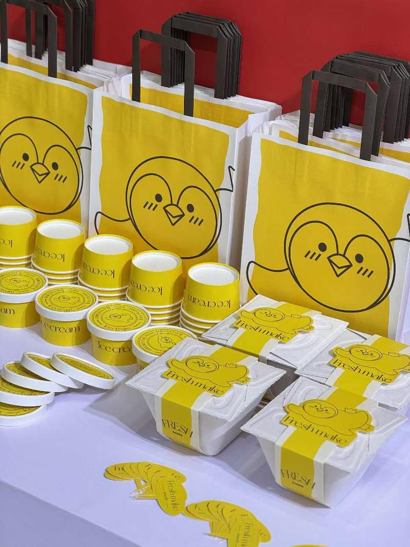 Reference photo showing a yellow cafe packaging range with cups, bags and boxes.